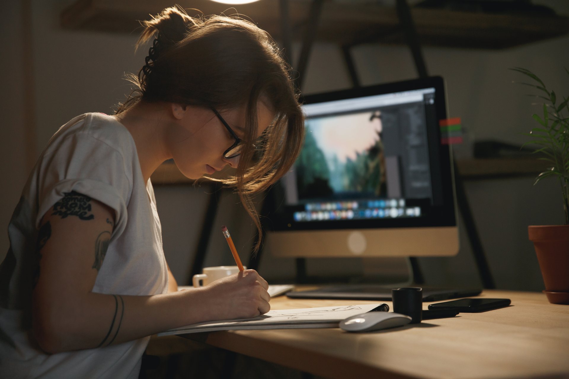 Profissional desenhando estudos de marca diante do computador